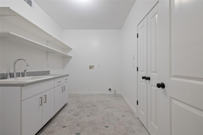 Washroom featuring cabinet space, hookup for a washing machine, and light tile patterned flooring | Image 21