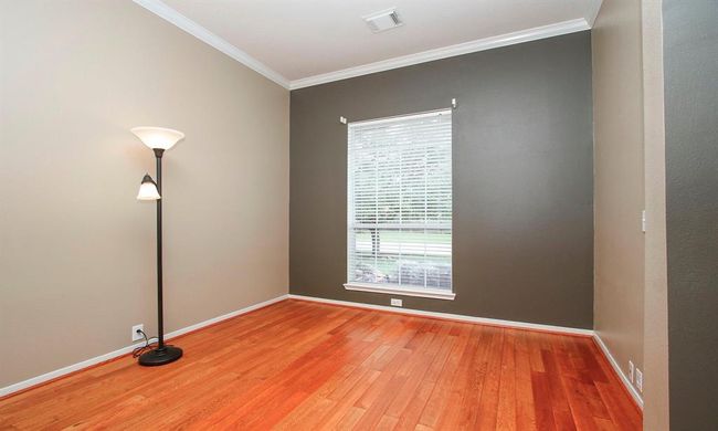 A handsome home office featuring hi-end wood-look tile floors, crown molding and lots of natural sunlight! | Image 5