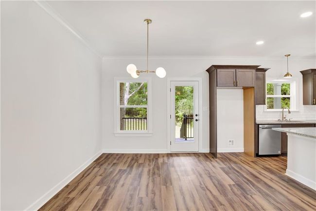 Kitchen featuring wood finished floors, ornamental molding, a sink, and dishwasher | Image 14