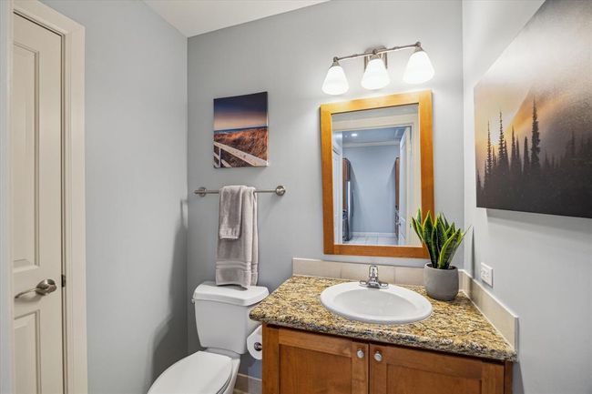 Hall guest bath with modern fixtures, a chic vanity, linen closet and a well-lit mirror, offering a stylish and practical space for visitors. | Image 11