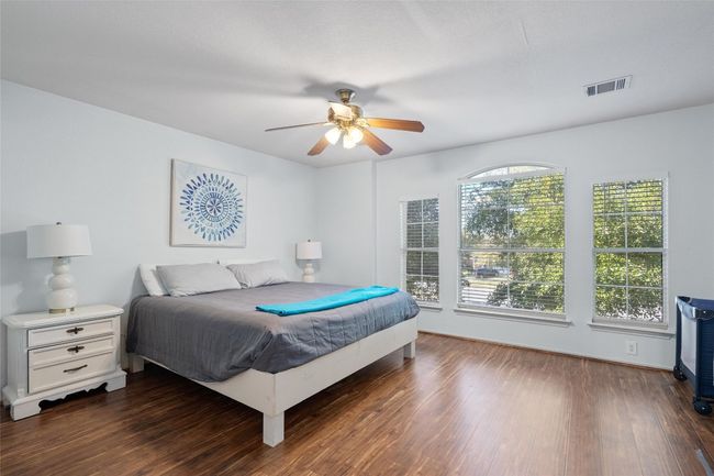 Bedroom featuring baseboards, dark wood finished floors, visible vents, and a ceiling fan | Image 18