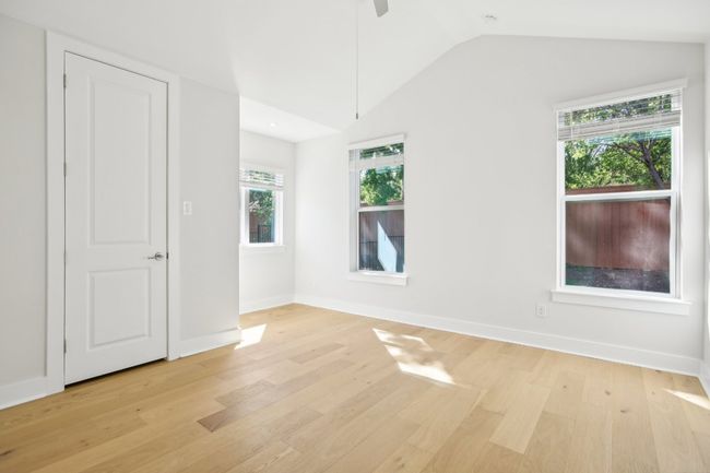 Unfurnished room with light wood-type flooring, baseboards, a ceiling fan, and lofted ceiling | Image 31