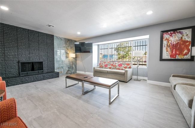 Living area with baseboards, recessed lighting, a textured ceiling, and a fireplace | Image 18