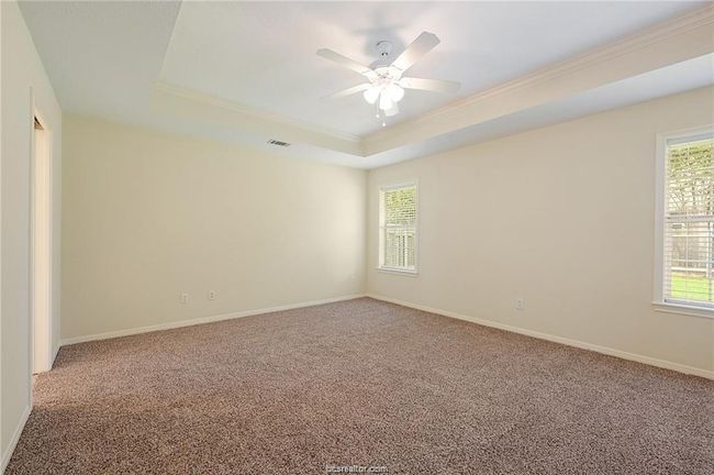 Unfurnished room with a raised ceiling, crown molding, carpet floors, ceiling fan, and baseboards | Image 14