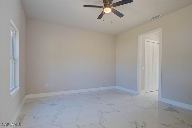 Spare room featuring a ceiling fan, marble finish floor, baseboards, and visible vents | Image 11