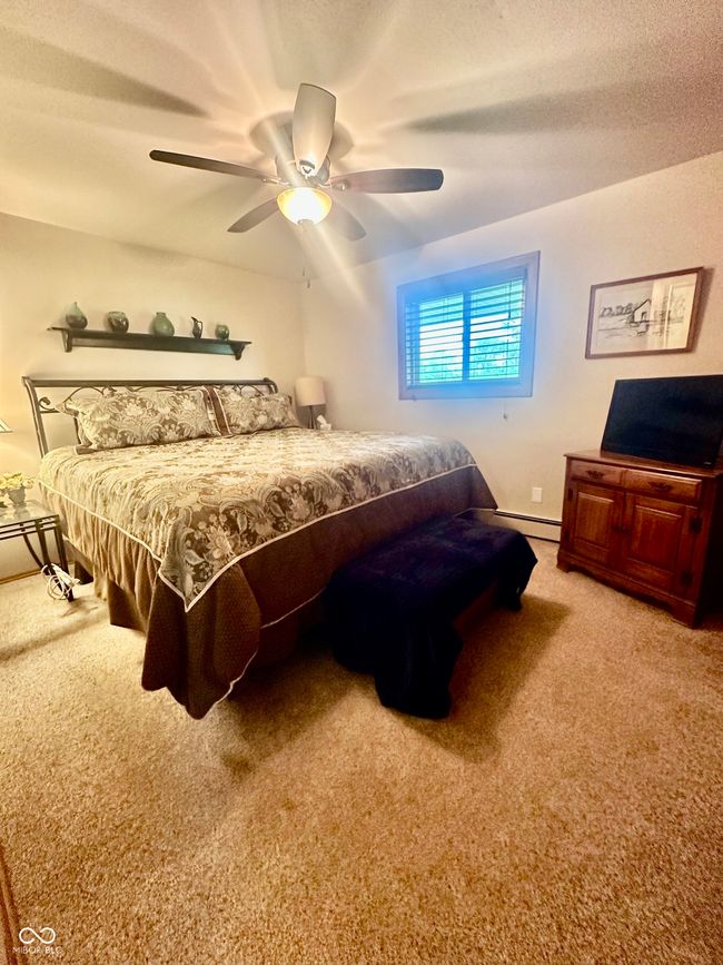 bedroom featuring carpet, baseboard heating, and ceiling fan | Image 26