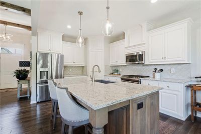 Kitchen with sink, appliances with stainless steel finishes, dark hardwood / wood-style floors, and white cabinetry | Image 2