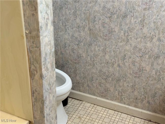 Bathroom with toilet, baseboards, and wallpapered walls | Image 26
