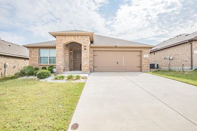 View of front of property with a front lawn, cooling unit, and a garage | Image 1