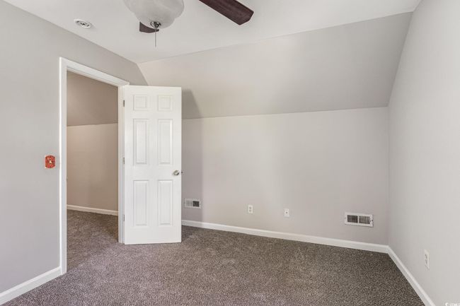 Additional living space featuring lofted ceiling, visible vents, a ceiling fan, and carpet | Image 18