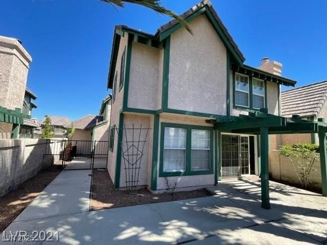 Back of property with a chimney, a gate, fence, and stucco siding | Image 13