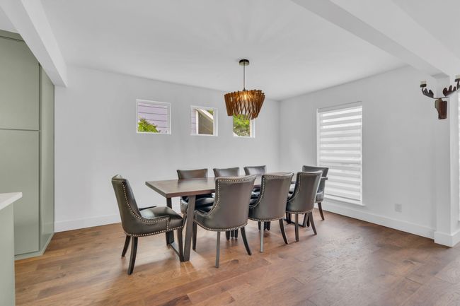 Dining room featuring baseboards, an inviting chandelier, and wood finished floors | Image 15