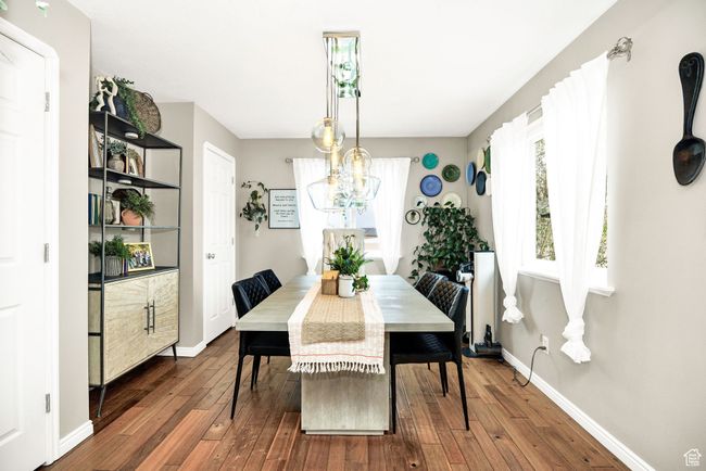 Dining room with a healthy amount of sunlight, an inviting chandelier, and wood-type flooring | Image 10