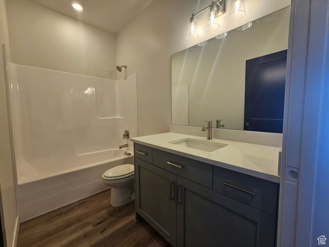 Bathroom featuring wood finished floors, vanity, toilet, shower / washtub combination, and recessed lighting | Image 22