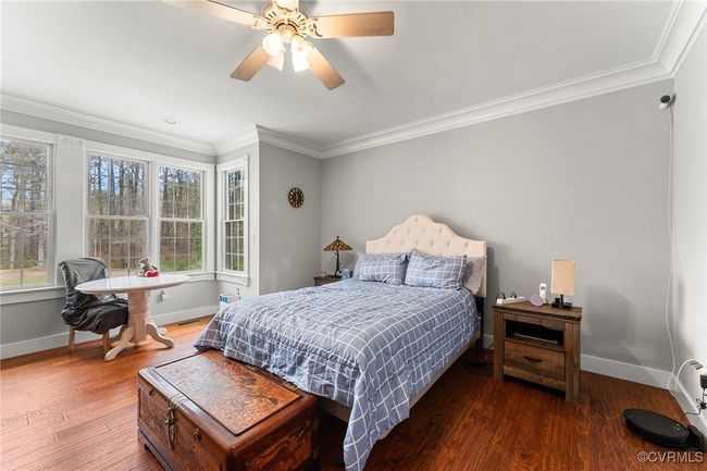 Bedroom with crown molding, wood finished floors, and a ceiling fan | Image 10
