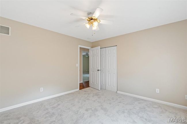 Unfurnished bedroom featuring carpet floors, baseboards, a closet, and ceiling fan | Image 19