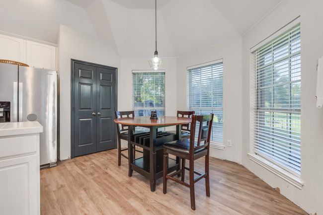 Dining area with light wood finished floors and lofted ceiling | Image 22