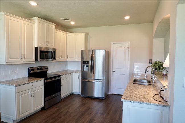 Kitchen featuring stainless steel appliances, a sink, light stone countertops, tasteful backsplash, and recessed lighting | Image 6