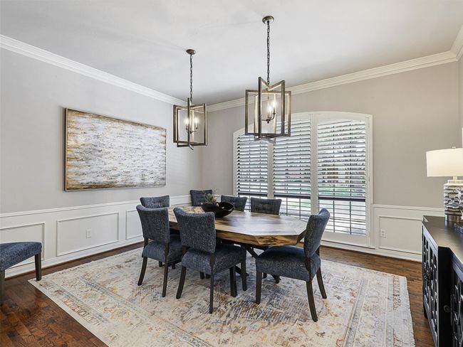 Dining room with ornamental molding, a chandelier, dark wood finished floors, a wainscoted wall, and a decorative wall | Image 16