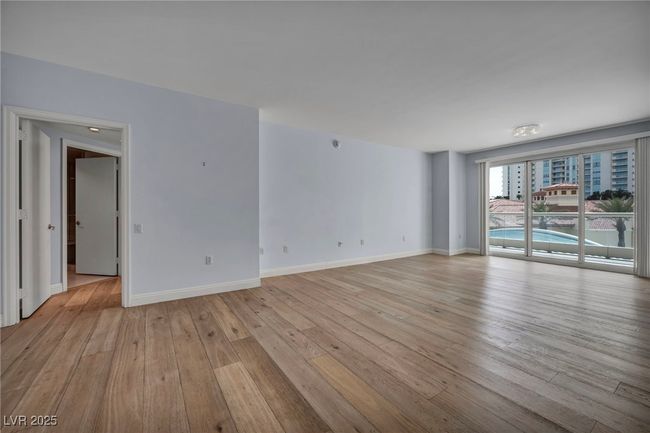 Unfurnished living room featuring baseboards and light wood-style flooring | Image 17