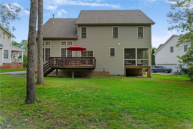 Back of house with a deck, crawl space, stairway, a yard, and a sunroom | Image 44