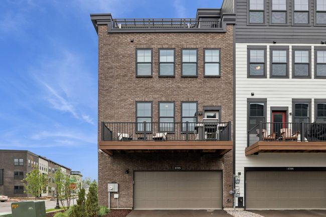 Rear of the unit showcases a deck/patio walkout from the main level, complete with a grill and seating—perfect for enjoying peaceful morning sunrises and beautiful river walk views. | Image 36