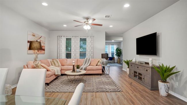 Living room featuring baseboards, a ceiling fan, wood finished floors, and visible vents | Image 10