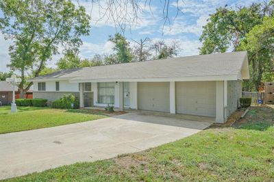 Single story home with a garage and a front lawn | Image 1