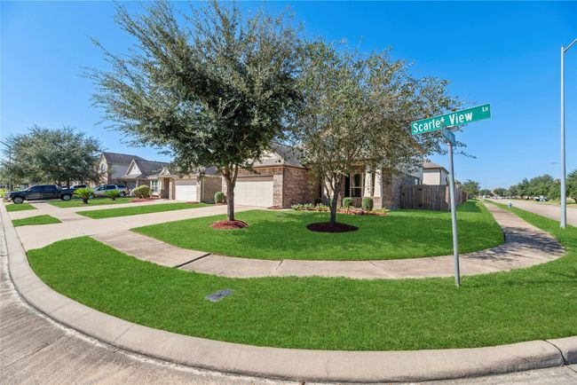 Resting on a gorgeous corner lot, this 4BR/3.5BA property is picturesque with traditional brick detailing, onyx black shutters, 2-car garage, and tidy landscaping. Combining formal touches with a welcoming vibe, the home invites guests with comfort and beauty. | Image 34