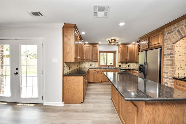 Kitchen with doors leading to backyard. Perfect for grilling! | Image 11