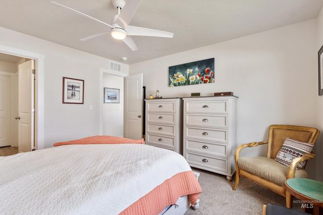 Bedroom featuring a ceiling fan and light colored carpet | Image 15