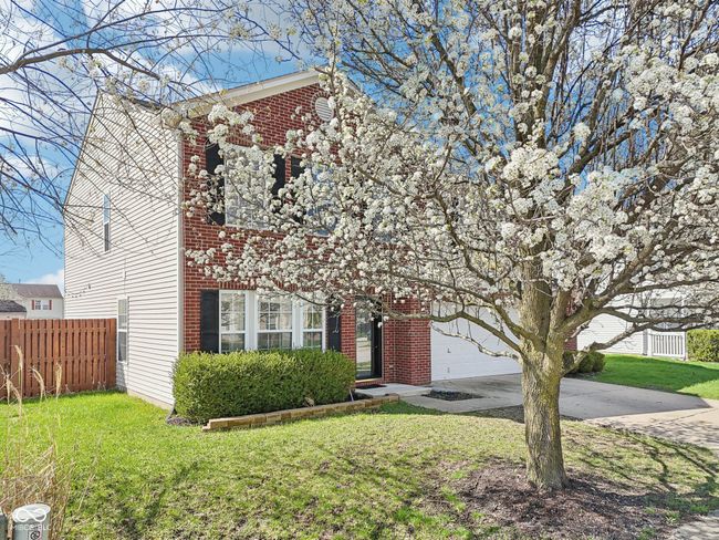 view of front facade with driveway, a garage, and brick siding | Image 73