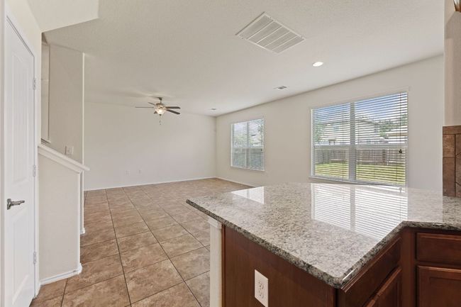 Kitchen with ceiling fan, light tile patterned flooring, light stone counters, and recessed lighting | Image 5