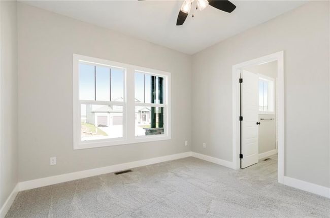 Unfurnished room featuring healthy amount of natural light, carpet floors, a ceiling fan, and baseboards | Image 12