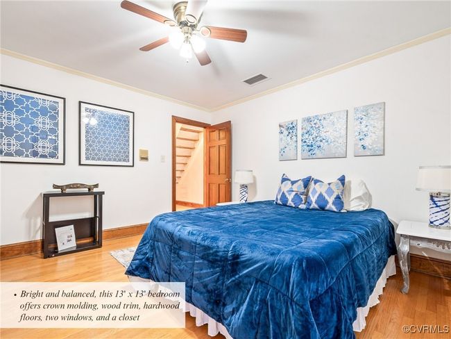 Bright and balanced, this 13' x 13' bedroom offers crown molding, wood trim, hardwood floors, two windows, and a closet | Image 32