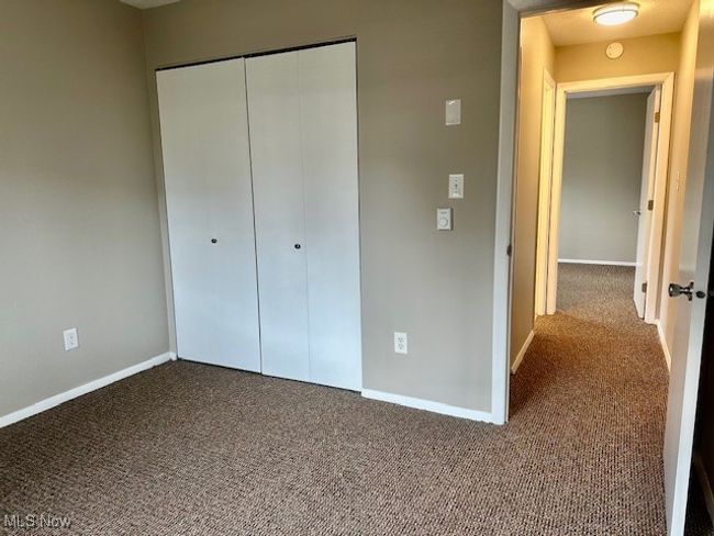 Unfurnished bedroom featuring carpet, a closet, and baseboards | Image 12
