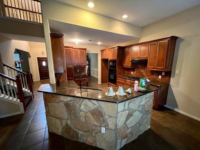 Kitchen featuring black appliances, tasteful backsplash, dark stone countertops, dark tile patterned floors, and recessed lighting | Image 6