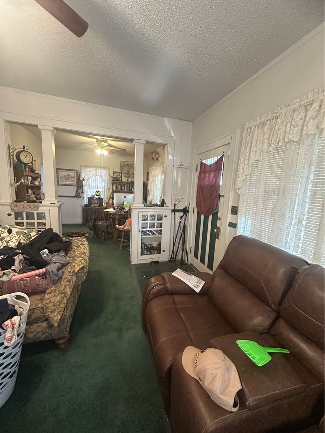 Dining room featuring ceiling fan, a textured ceiling, ornate columns, and carpet flooring | Image 8