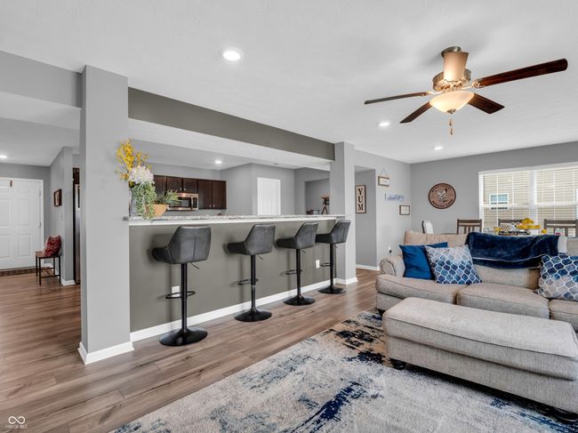 living area with breakfast bar, recessed lighting, beautiful flooring, and ceiling fan | Image 15