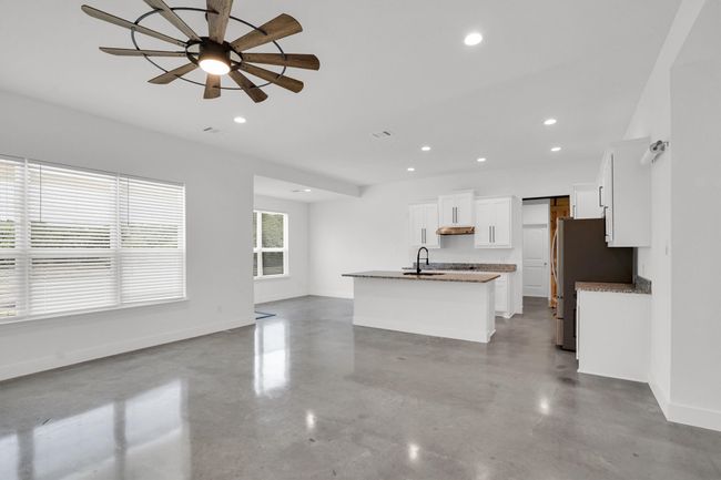 Unfurnished living room featuring a sink, baseboards, finished concrete flooring, a ceiling fan, and recessed lighting | Image 16