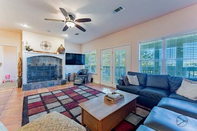 Main living area has wood burning fireplace and French doors which lead out to a huge screened balcony offering excellent views of the deep open water. | Image 9