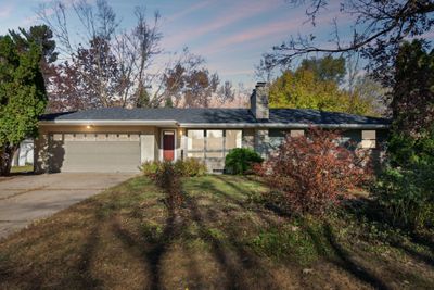 One level living with attached garage at dusk. | Image 2