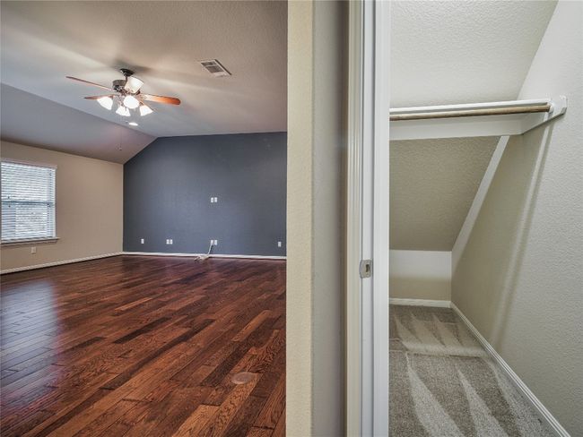 Bonus room with ceiling fan, vaulted ceiling, wood finished floors, baseboards, and a textured ceiling | Image 30