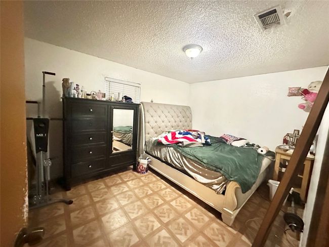 Bedroom featuring tile patterned floors and a textured ceiling | Image 29