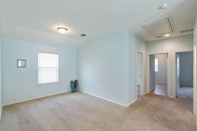 Carpeted spare room featuring attic access, plenty of natural light, a smoke detector, and lofted ceiling | Image 5