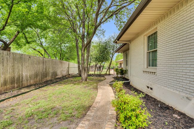 Stone and brick walking paths surround this home. In the distance, you will see an old cistern, and the Potting Shed. | Image 27