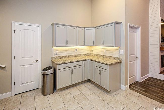 Kitchen with light stone countertops and light tile patterned floors | Image 15