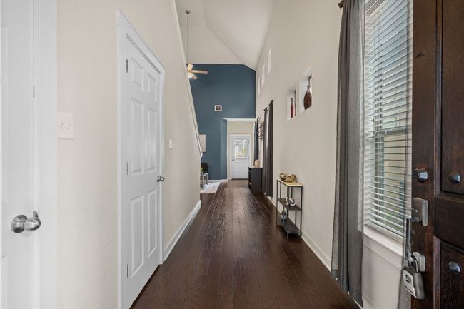 Corridor featuring baseboards, dark wood-style floors, and high vaulted ceiling | Image 4