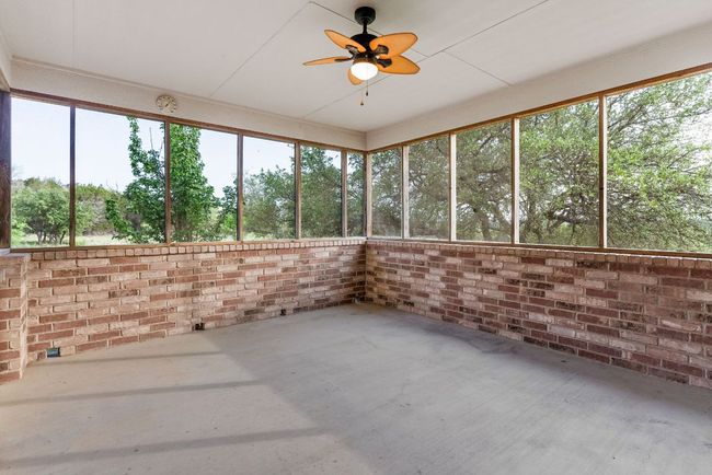 Unfurnished sunroom featuring a wealth of natural light and ceiling fan | Image 33
