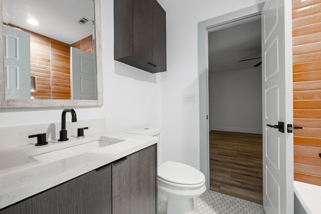 Bathroom with tile patterned flooring, visible vents, toilet, and vanity | Image 27
